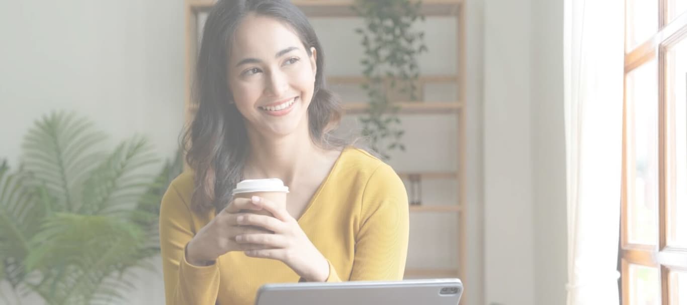 Mujer con un café evaluando opciones de inversión en una tablet